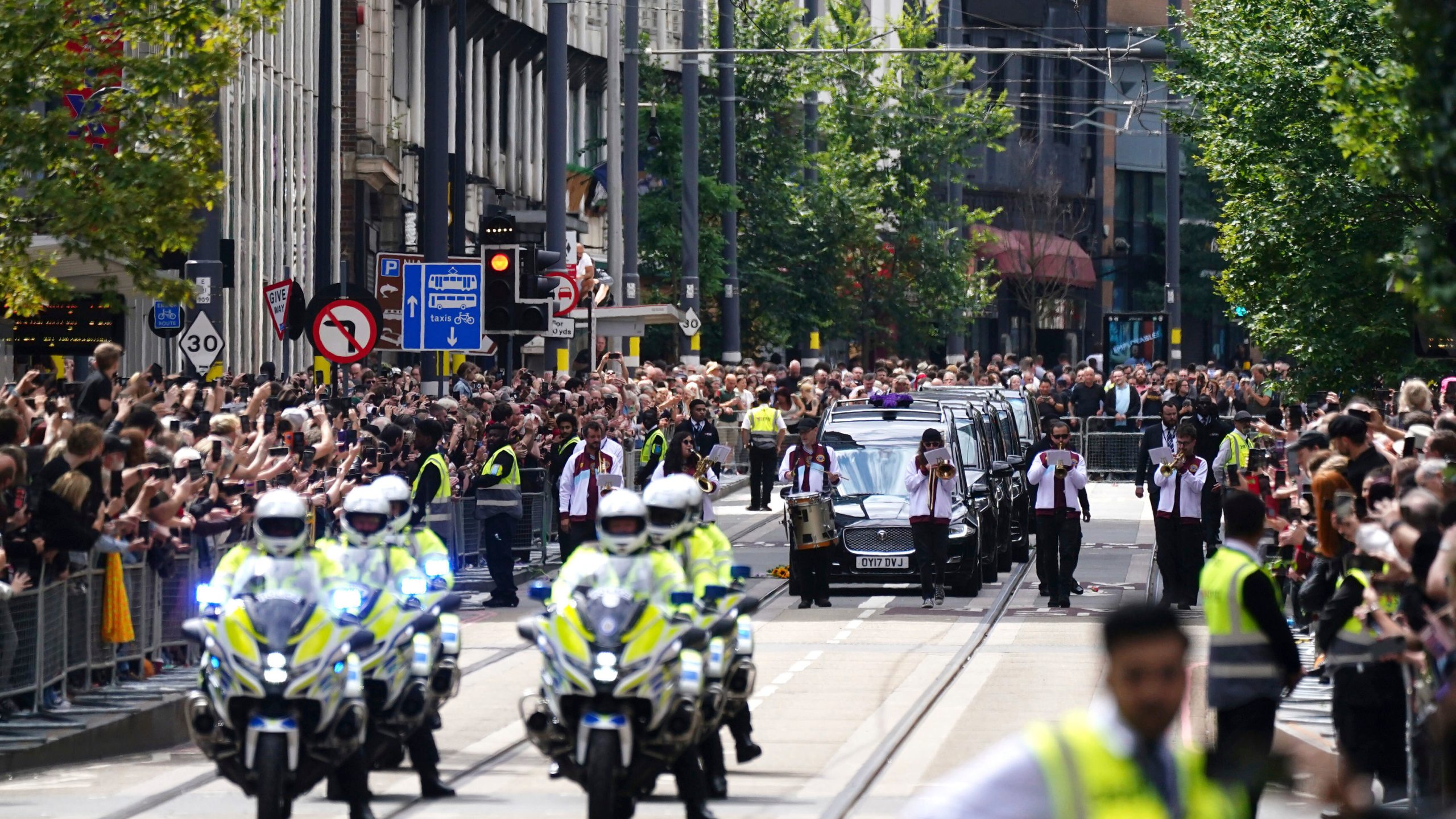 The funeral cortege of Black Sabbath frontman Ozzy Osbourne travels along Broad Street during his funeral procession, in Birmingham, England, Wednesday July 30, 2025. (Jacob King/PA via AP)