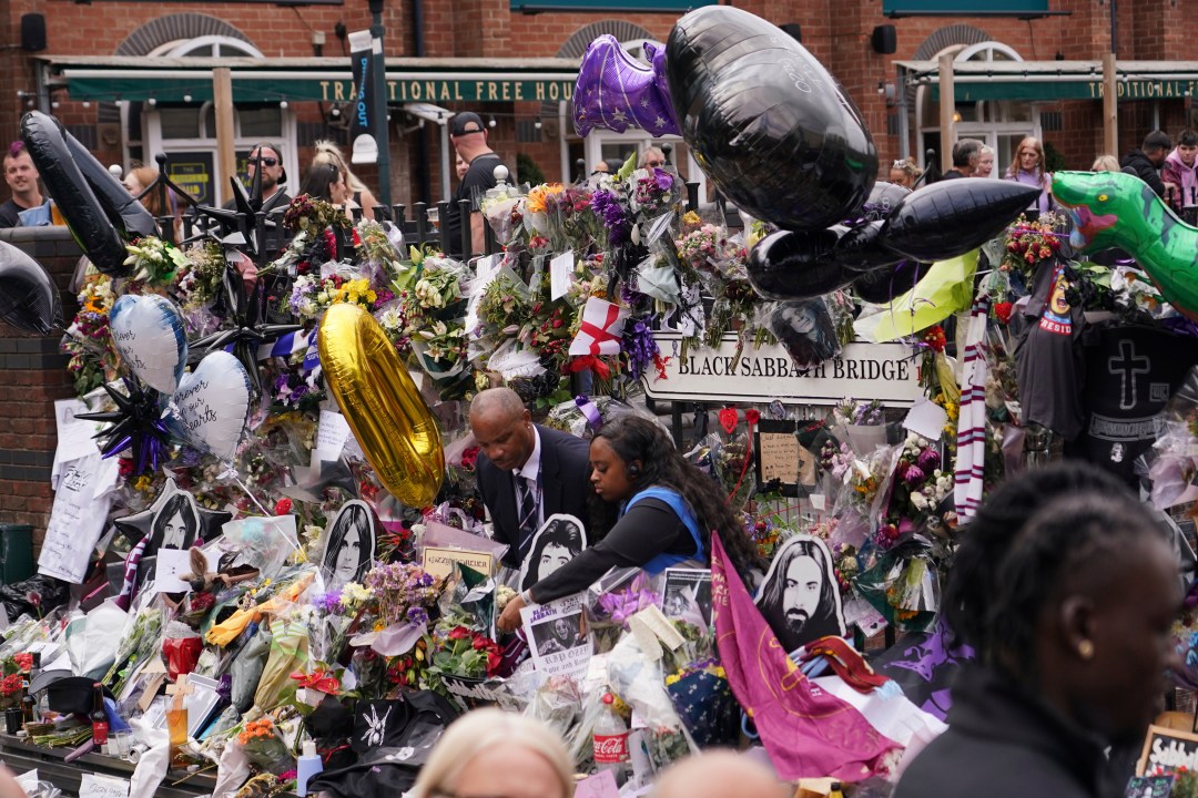 Floral tributes in front of the 'Black Sabath bridge' to honour musician Ozzy Osbourne as thousands of fans gathered to watch a funeral procession for Black Sabbath frontman Ozzy Osbourne following his death aged 76, in Birmingham, England, Wednesday, July 30, 2025. (AP Photo/Alberto Pezzali)
