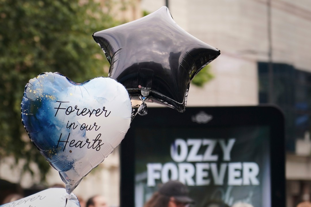 A balloon near a sign to honour musician Ozzy Osbourne as thousands of fans gathered to watch a funeral procession for Black Sabbath frontman Ozzy Osbourne following his death aged 76, in Birmingham, England, Wednesday, July 30, 2025. (AP Photo/Alberto Pezzali)