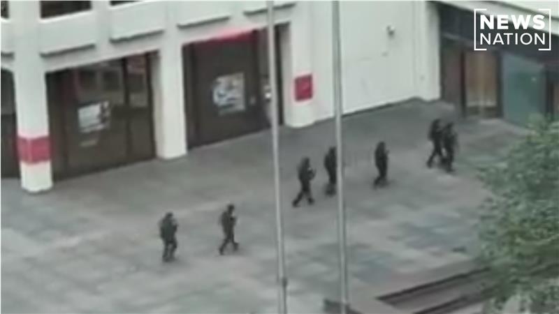 Police are seen swarming a building in Midtown Manhattan after reports of an active shooter in New York City