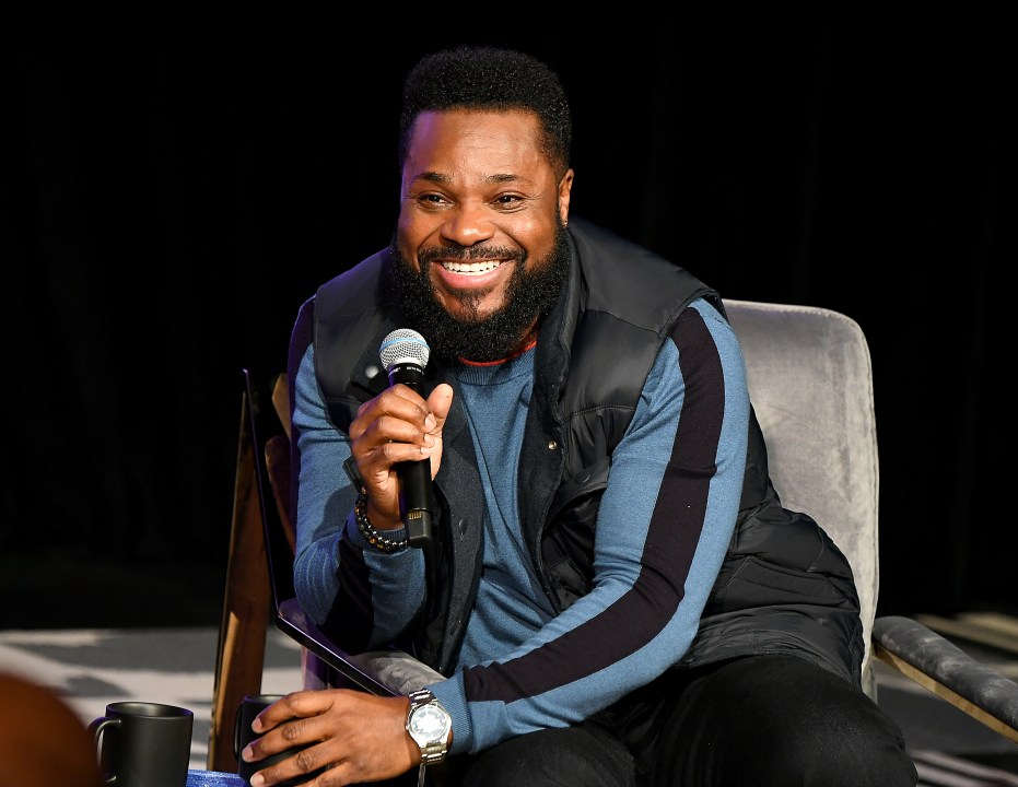 Malcolm-Jamal Warner hokding a microphone
