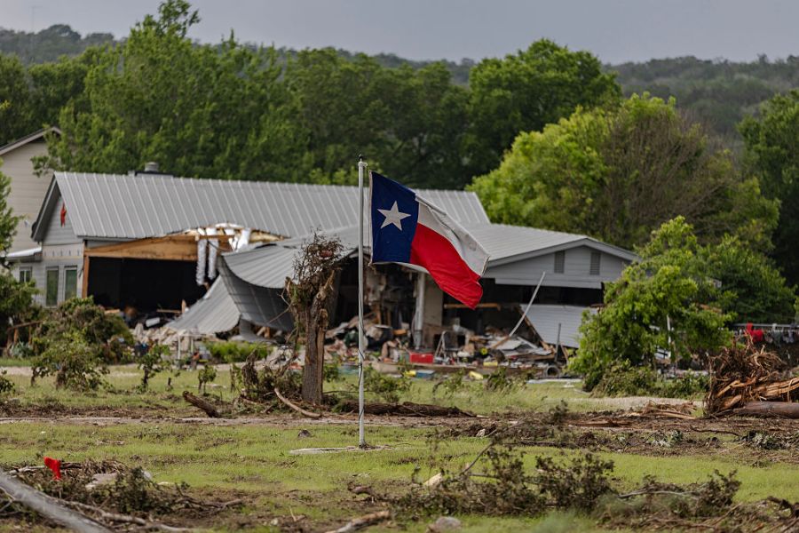 A Texas state flag flies in a yard