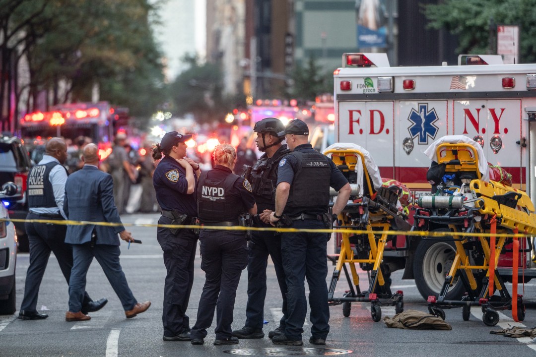 New York Police Department officers stand next to ambulance