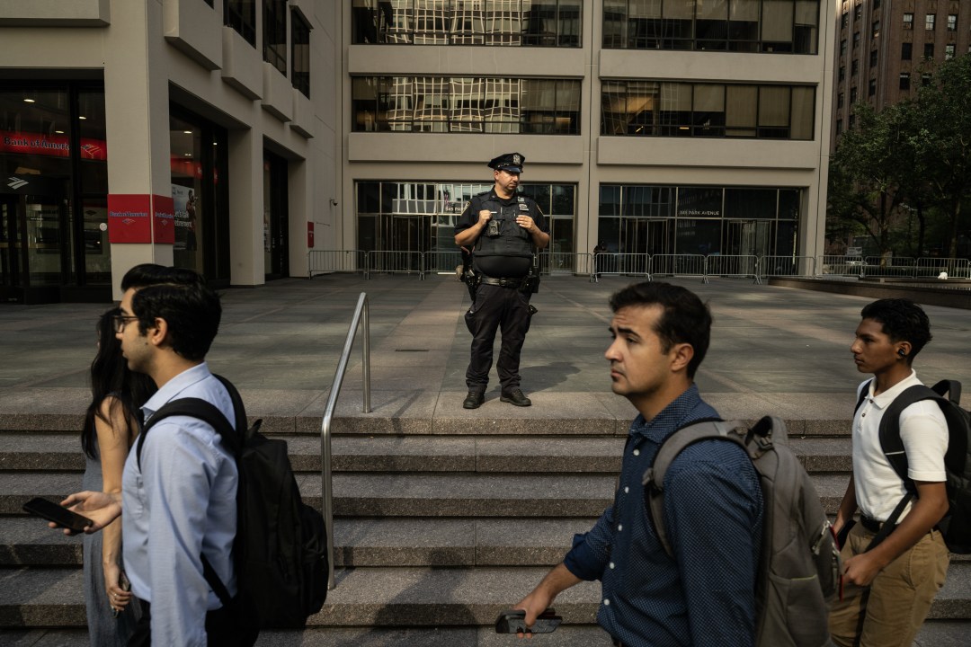 New York Police Department officer stands outside building