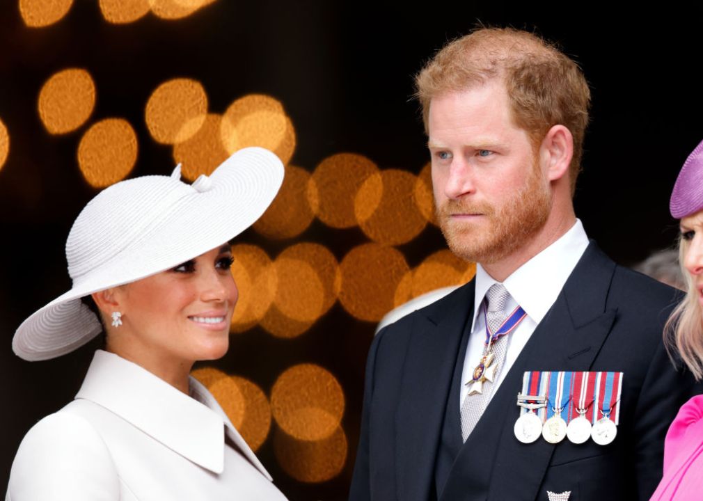 Meghan Markle in white and Prince Harry uniform