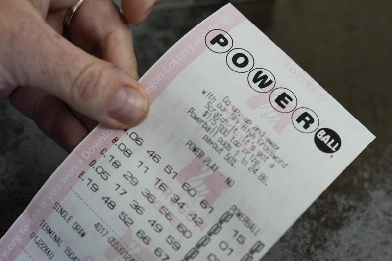 A person shows their Powerball lottery ticket at a 7-Eleven on Friday, April 5, 2024, in Portland, Ore.