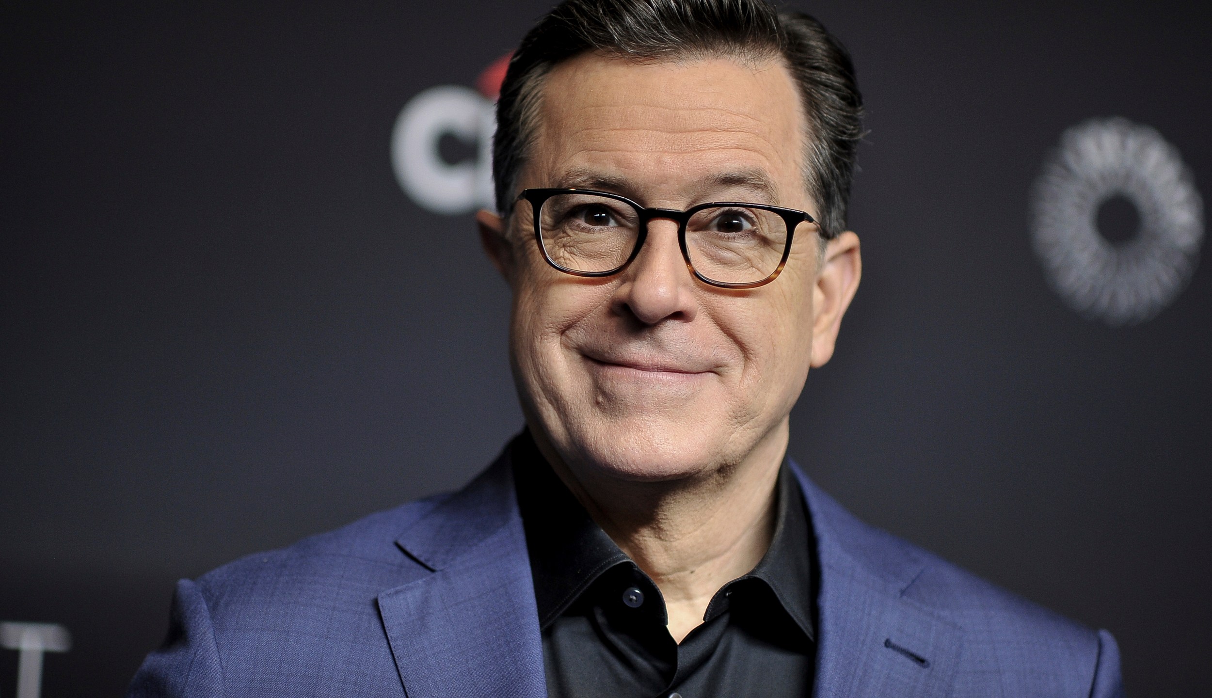 Stephen Colbert smiles at an event