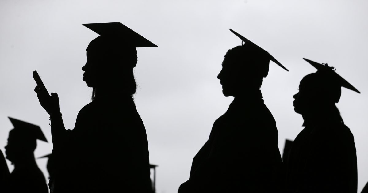 New graduates line up before the start of their college commencement.