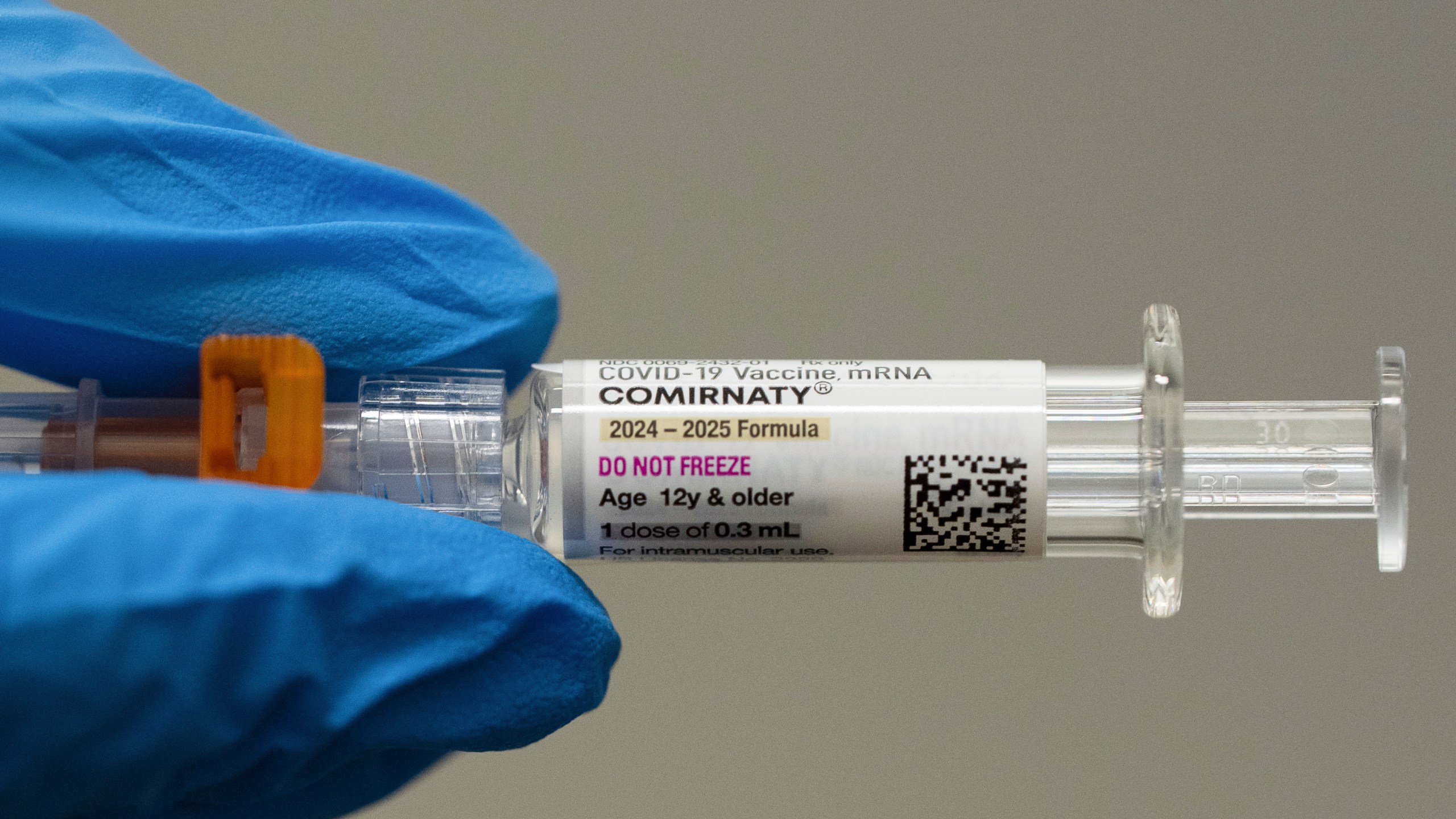 FILE - A pharmacist holds a Pfizer and BioNTech COVID-19 vaccine shot on Thursday, April 24, 2025, in Portland, Ore. (AP Photo/Jenny Kane, File)