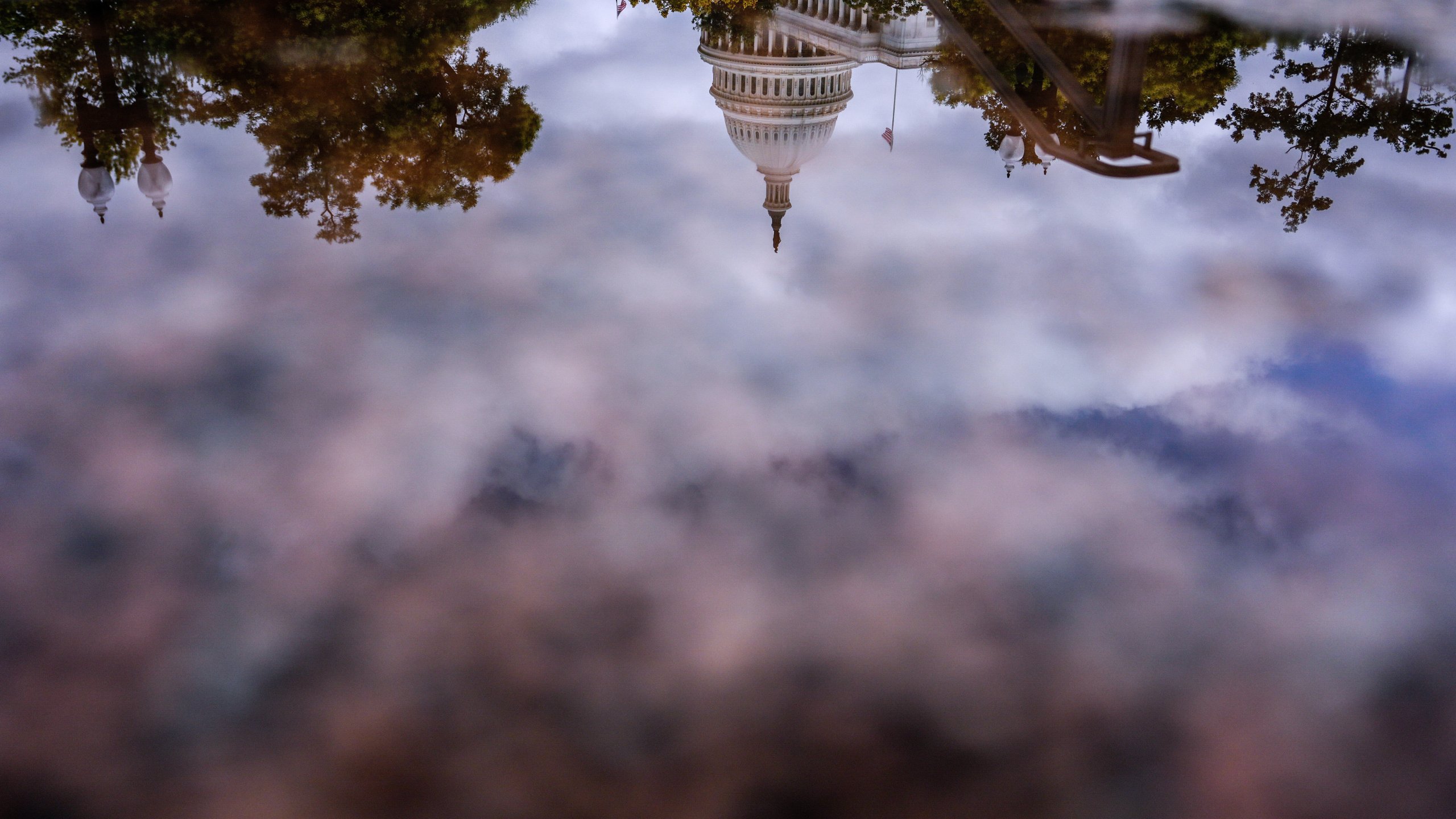 The U.S. Capitol is reflected in a puddle outside of the Rayburn House Office Building, Wednesday, July 16, 2025, on Capitol Hill in Washington. (AP Photo/Julia Demaree Nikhinson)