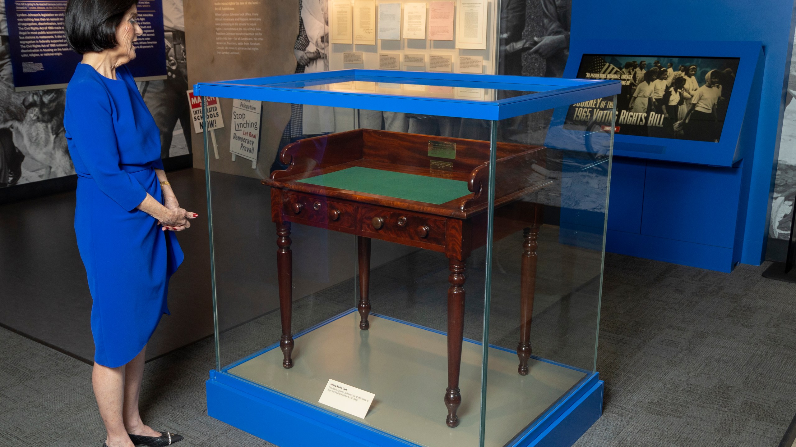 FILE - Luci Baines Johnson looks at the desk May 16, 2023, on display at the LBJ Presidential Library, that President Lyndon B. Johnson sat at in the President's Room at the U.S. Capitol to sign the Voting Rights Act of 1965, on Aug. 6, 1965. (AP Photo/Stephen Spillman, File)