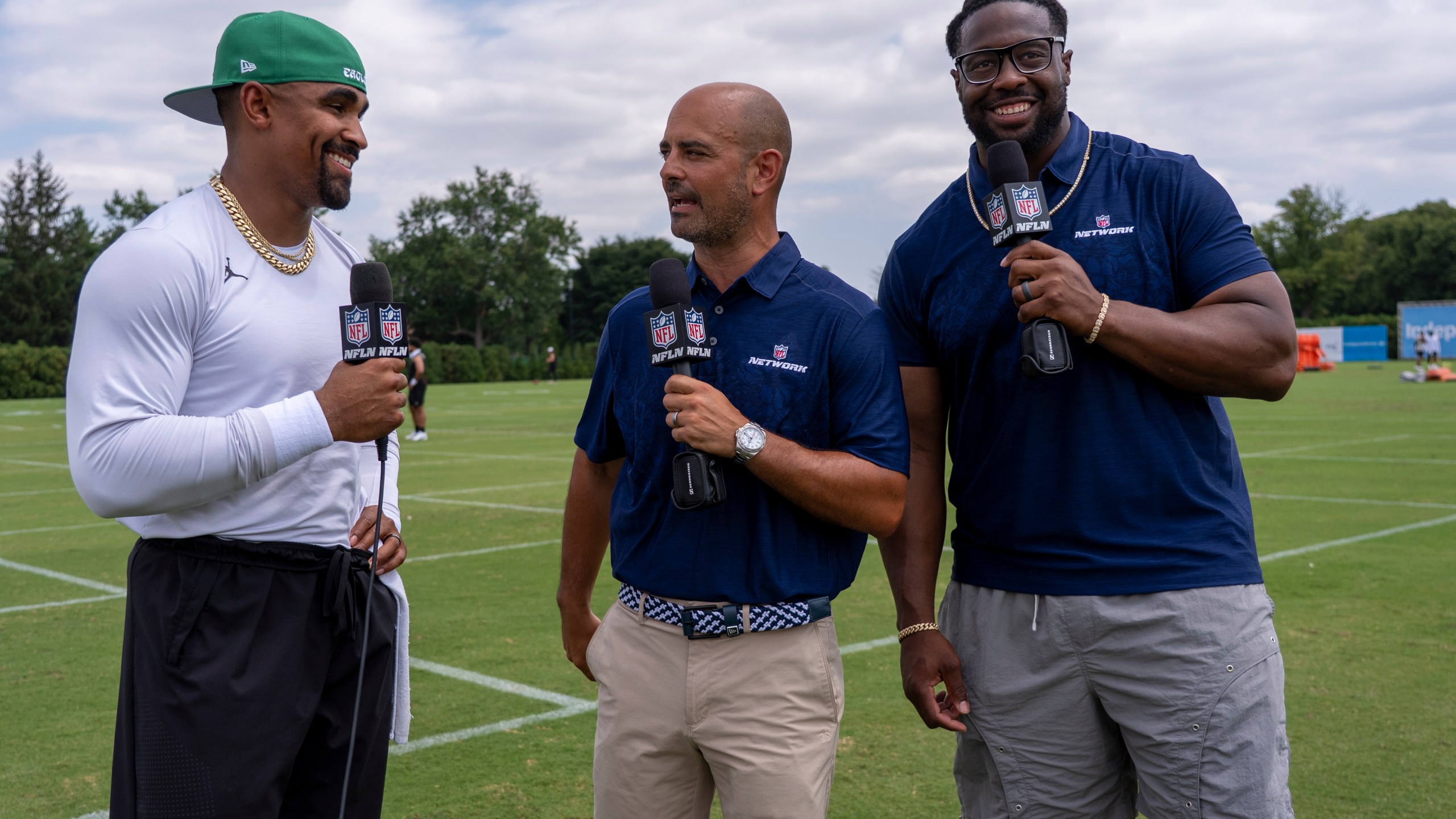 Philadelphia Eagles' Jalen Hurts, left, is interviewed by NFL Network talent Mike Garafolo, center, and Gerald McCoy, right, following practice at the team's NFL football training camp, Saturday, July 26, 2025, in Philadelphia. (AP Photo/Chris Szagola)