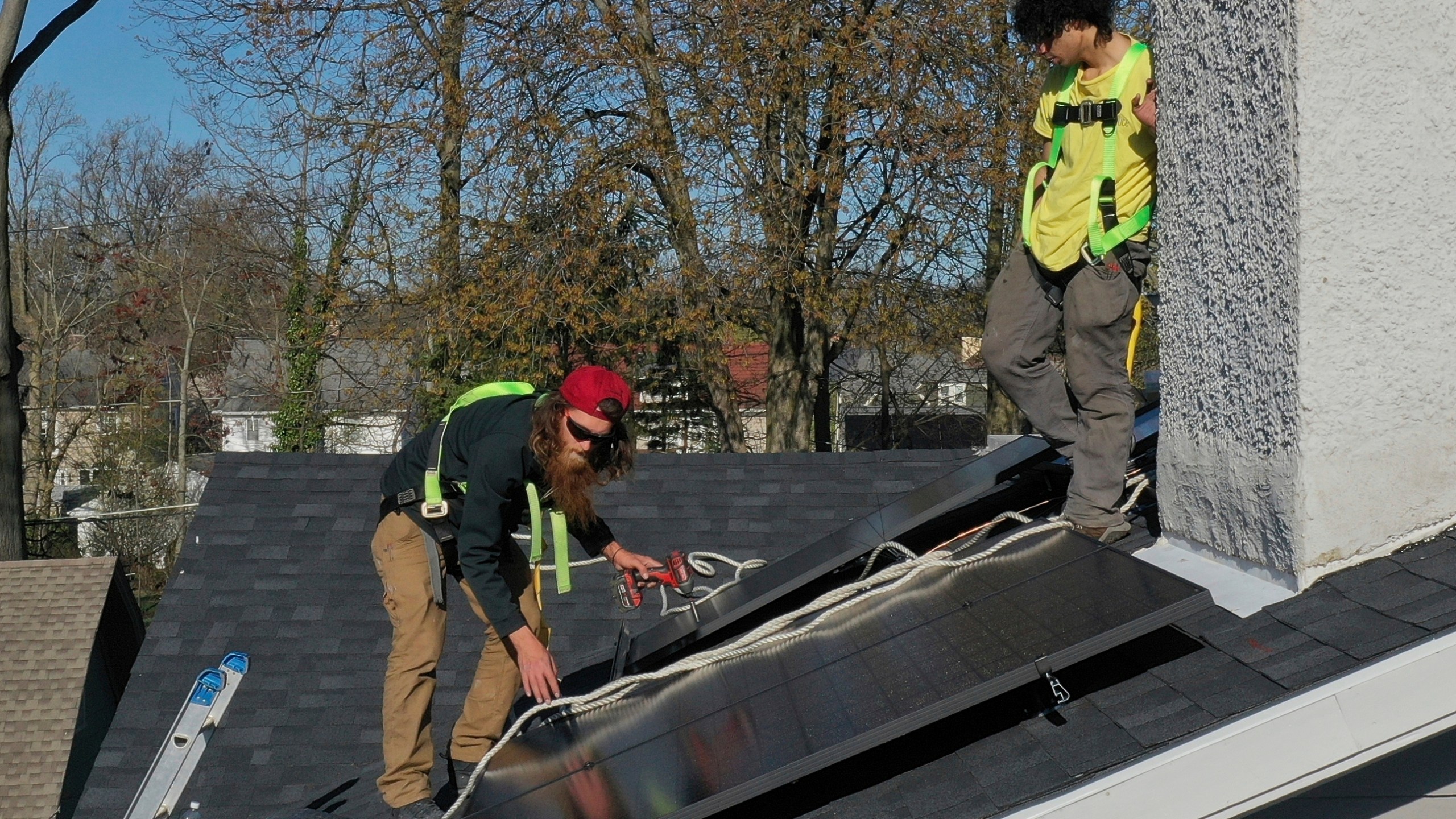 FILE - Theodore Tanczuk, left, and Brayan Santos, of solar installer YellowLite, put solar panels on the roof of a home in Lakewood, Ohio, April 17, 2025. (AP Photo/Sue Ogrocki, File)