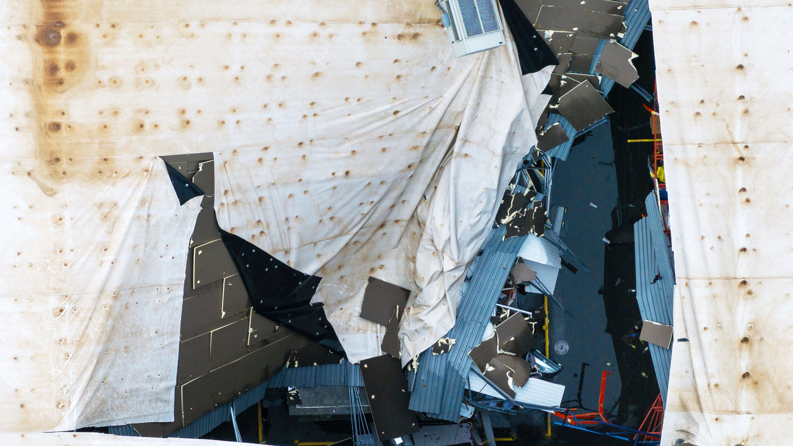A hole is seen in the roof of the Dollar General distribution warehouse located at 1200 S 10th Streeet in Blair, Neb. on Saturday, Aug. 9, 2025, after an early morning storm caused widespread wind damage in the area. (Chris Machian/Omaha World-Herald via AP)
