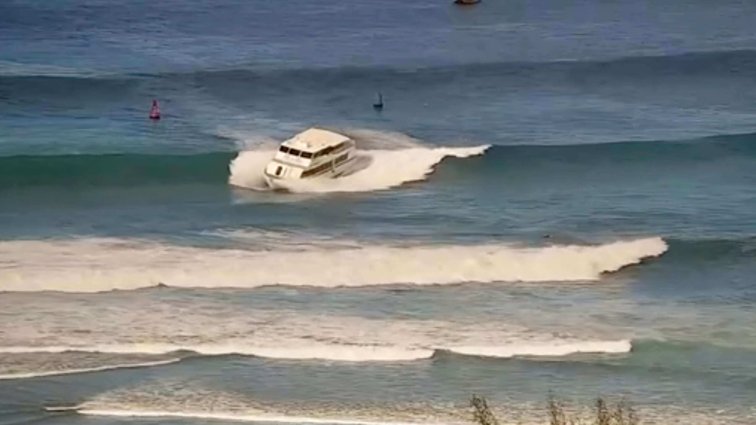 This still image from video and provided by the U.S. Coast Guard shows a 75-foot passenger vessel running aground near Kewalo Basin Harbor, Honolulu, on Saturday, Aug. 9, 2025. (U.S. Coast Guard via AP)