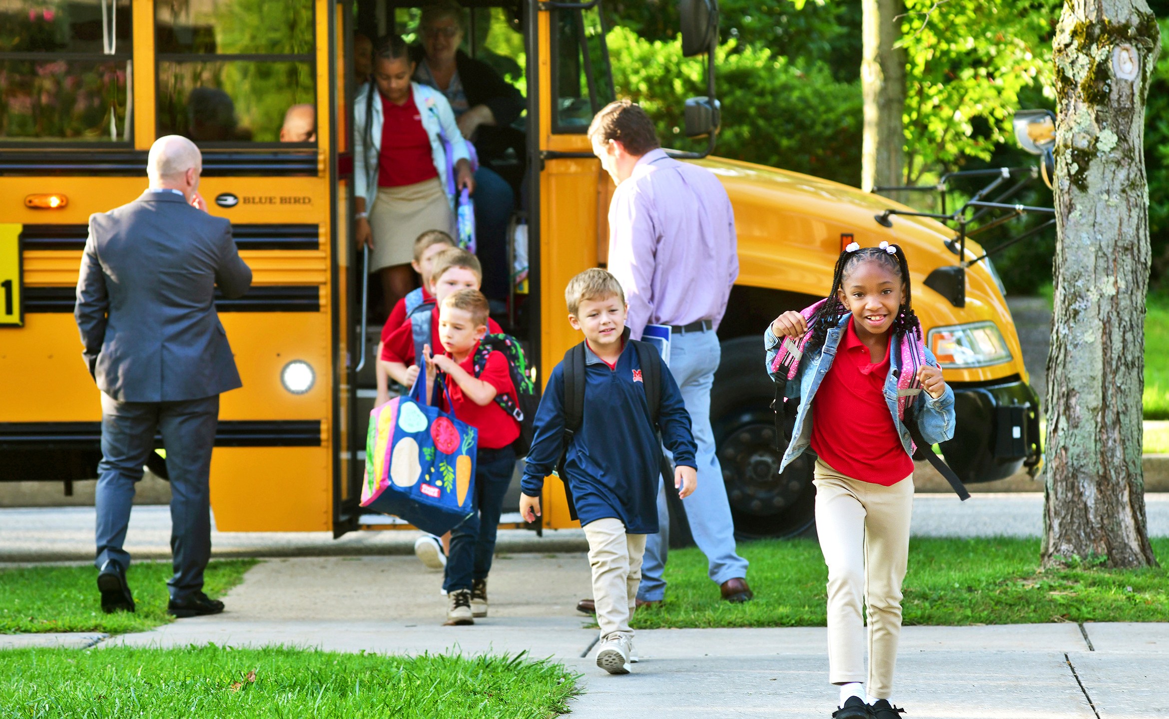 FILE - Second-grader Aaminah Ingram-Kirk, 7, leads the way off the bus for the first day of school at Bishop McCort Catholic Elementary West on Tioga Street in Johnstown, Pa., Aug. 21, 2024. (Thomas Slusser/The Tribune-Democrat via AP, File)