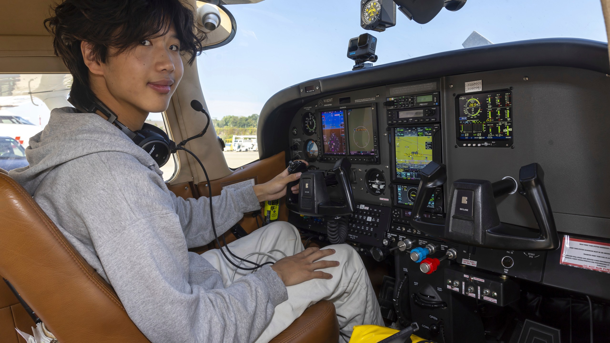 Ethan Guo poses for a photo in the cockpit of a plane