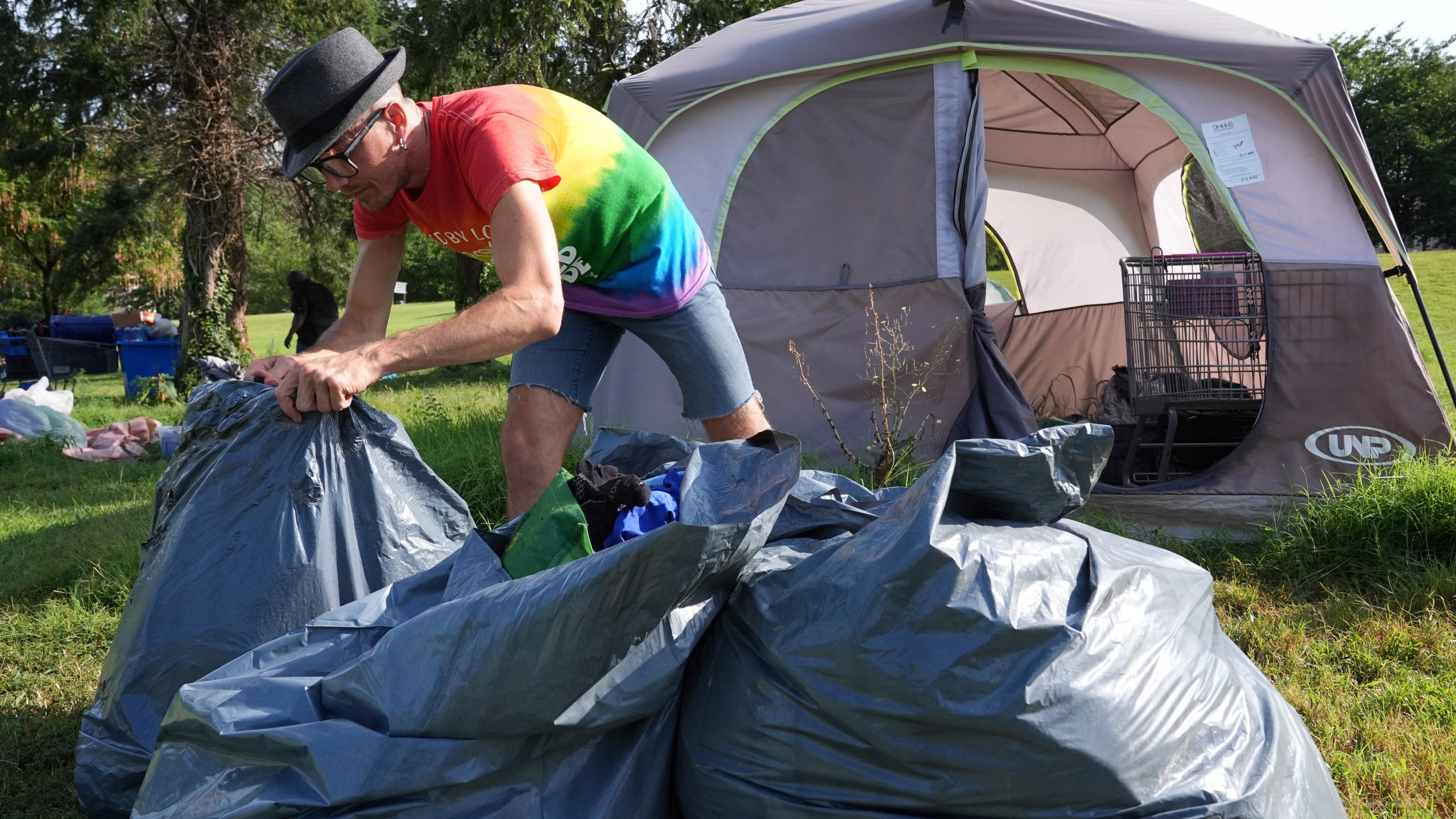 Jesse Wall, 43, clears up a tent encampment, Thursday, Aug. 14, 2025, where people who are homeless have been living in Washington. (AP Photo/Jacquelyn Martin)