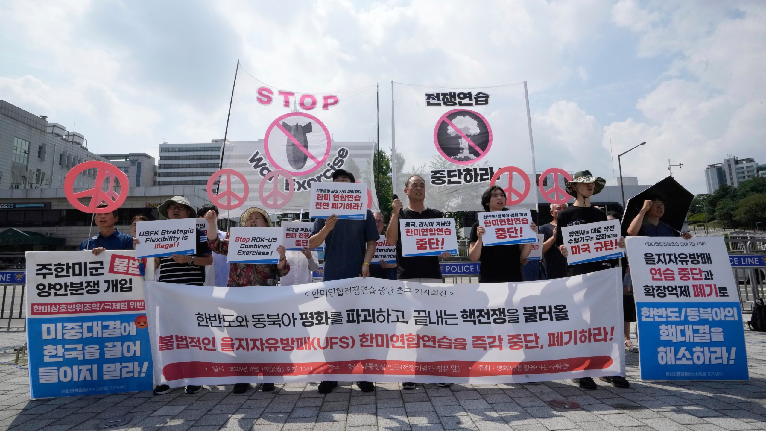 South Korean protesters stage a rally to oppose the joint military exercises, Ulchi Freedom Shield or UFS, between the U.S. and South Korea in front of the presidential office in Seoul, South Korea, Monday, Aug. 18, 2025. The banners read "Stop the military exercise between the U.S. and South Korea." (AP Photo/Ahn Young-joon)
