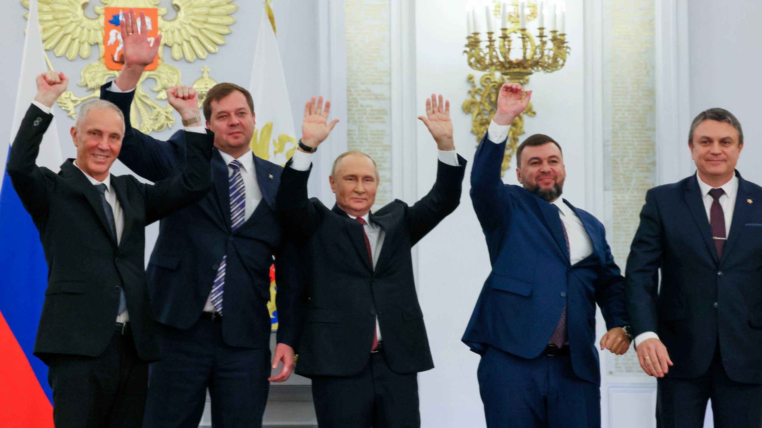 FILE - Russian President Vladimir Putin, center, with from left, Moscow-appointed head of Kherson Region Vladimir Saldo, Moscow-appointed head of Zaporizhzhia region Yevgeny Balitsky, Denis Pushilin, the leader of the Donetsk People's Republic and Leonid Pasechnik, leader of self-proclaimed Luhansk People's Republic wave during a ceremony to sign the treaties for four regions of Ukraine to join Russia, at the Kremlin, Moscow, Sept. 30, 2022. The signing of the treaties making the four regions part of Russia follows the completion of the Kremlin-orchestrated "referendums." (Mikhail Metzel, Sputnik, Kremlin Pool Photo via AP, File)