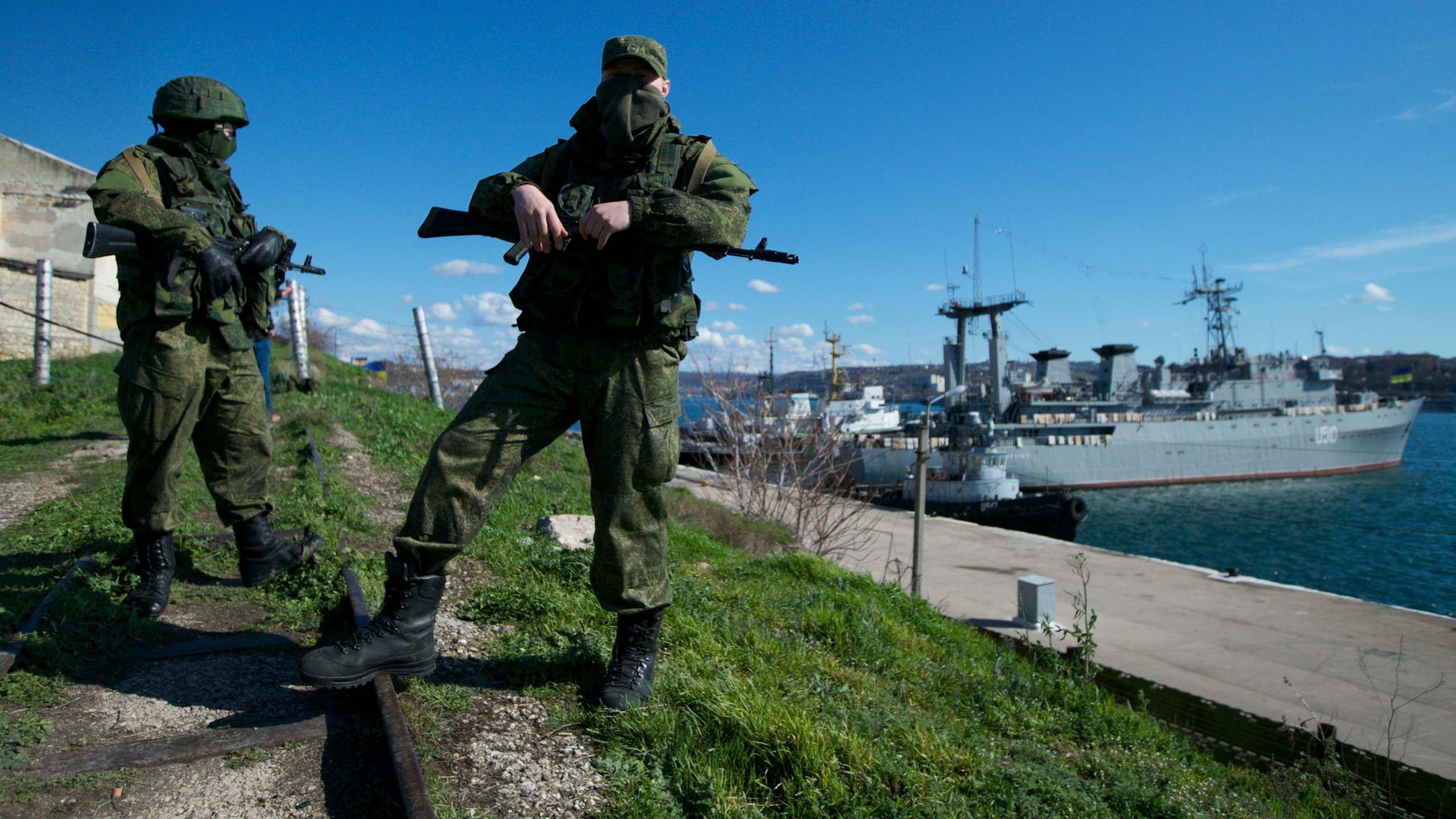 FILE - Russian soldiers guard a pier where two Ukrainian naval vessels are moored, in Sevastopol, on the Crimean Peninsula, March 5, 2014. (AP Photo, File)