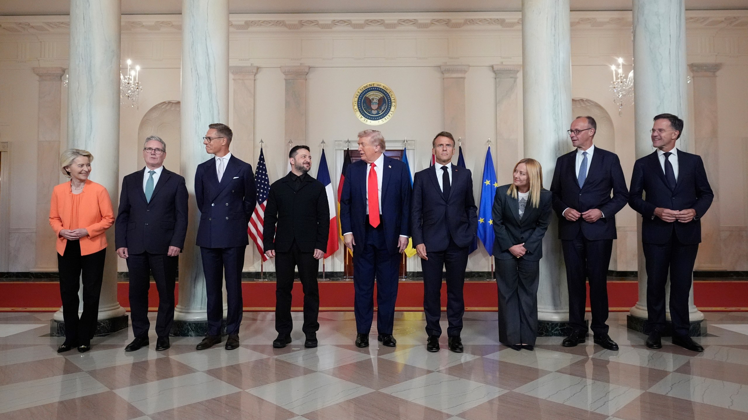 European Commission President Ursula von der Leyen, from left, British Prime Minister Keir Starmer, Finland's President Alexander Stubb, Ukrainian President Volodymyr Zelenskyy, President Donald Trump, France's President Emmanuel Macron, Italy's Prime Minister Giorgia Meloni, Germany's Chancellor Friedrich Merz and NATO Secretary General Mark Rutte stand before a group photo in the Grand Foyer of the White House, Monday, Aug. 18, 2025, in Washington. (AP Photo/Alex Brandon)