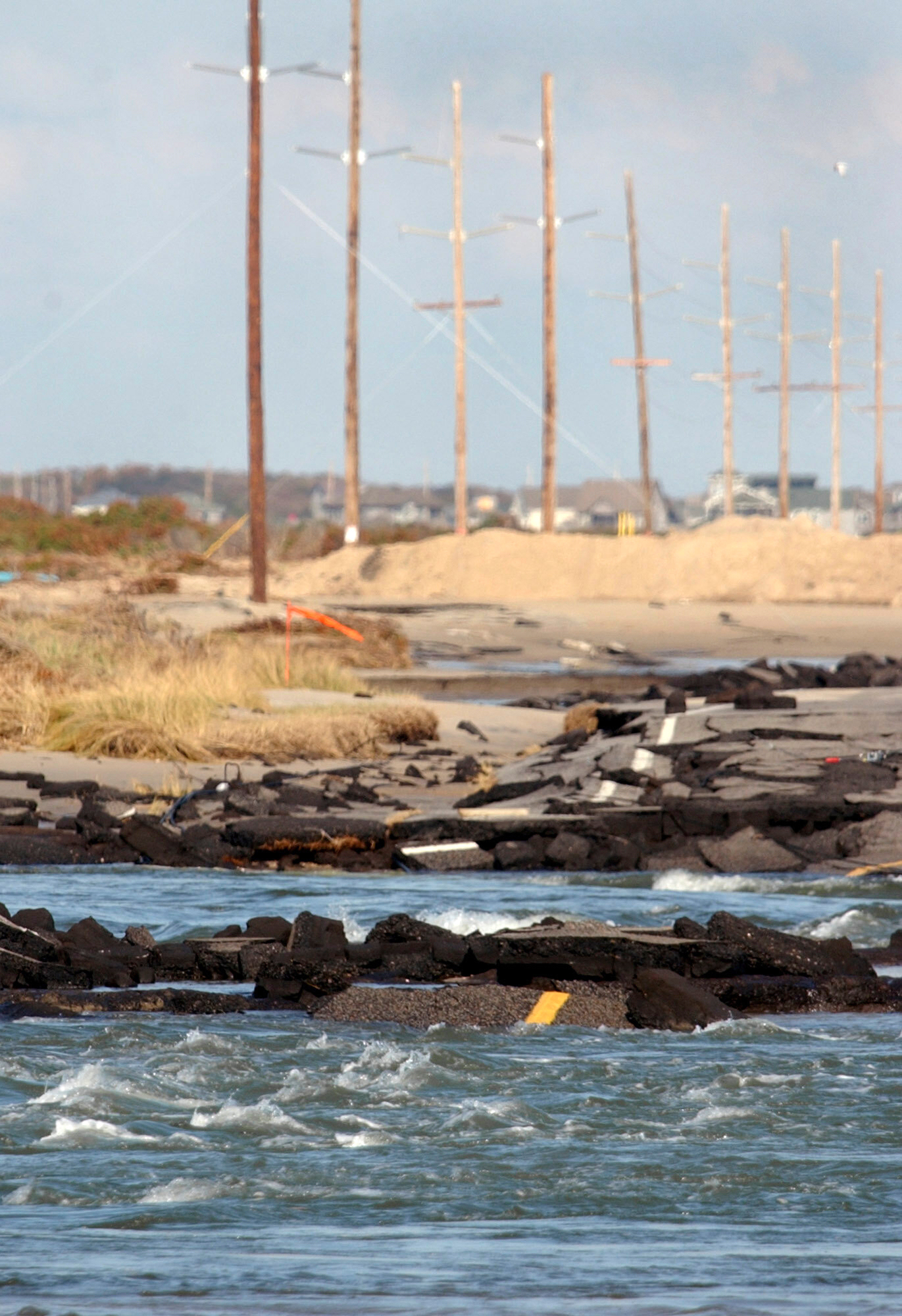 FILE - Waves wash over what remains of N.C. Highway 12 that once linked Hatteras Village, N.C., to the rest of the Outer Banks, Sept. 29, 2003. (AP Photo/Carolyn Kaster, File)