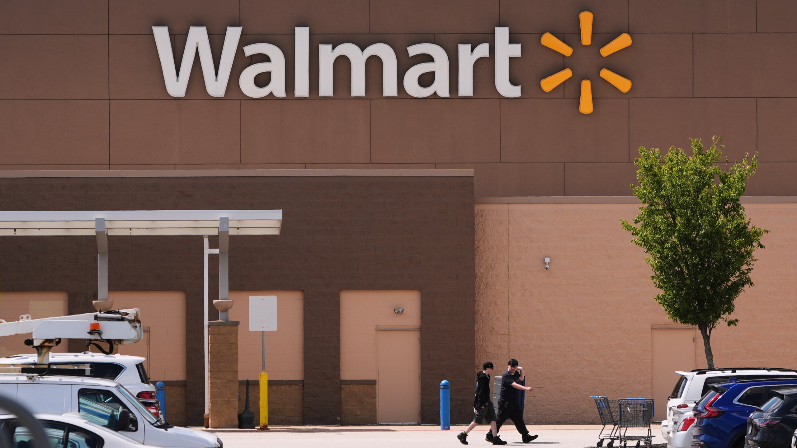 FILE - Shoppers walk from the Walmart store, Aug. 14, 2025, in Manchester, N.H. (AP Photo/Charles Krupa, file)