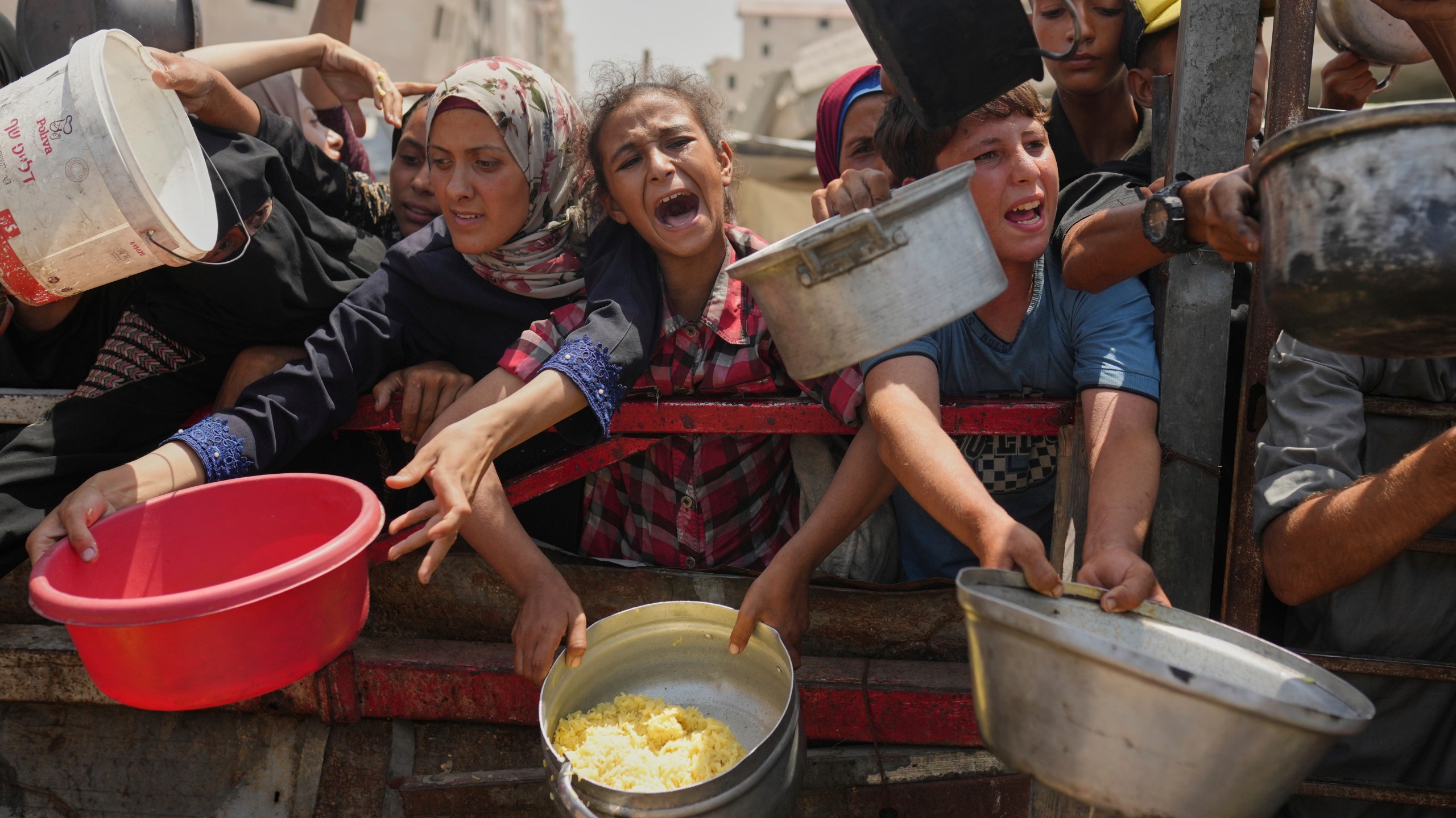 FILE - Palestinians struggle to get donated food at a community kitchen in Gaza City, northern Gaza Strip, Saturday, Aug. 16, 2025. (AP Photo/Jehad Alshrafi, File)