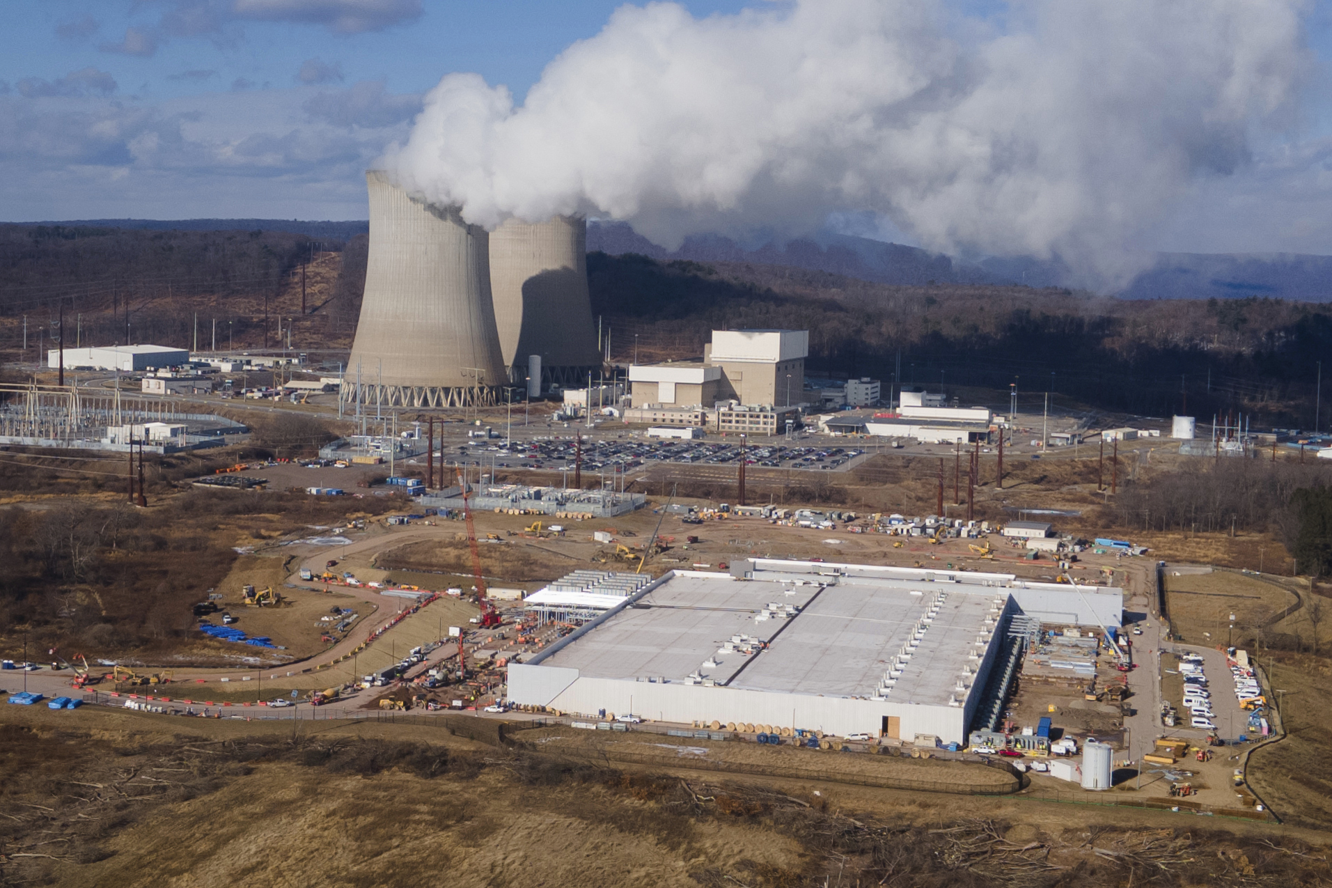 FILE - A data center owned by Amazon Web Services, front right, is under construction next to the Susquehanna nuclear power plant in Berwick, Pa., on Jan. 14, 2025. (AP Photo/Ted Shaffrey, file)