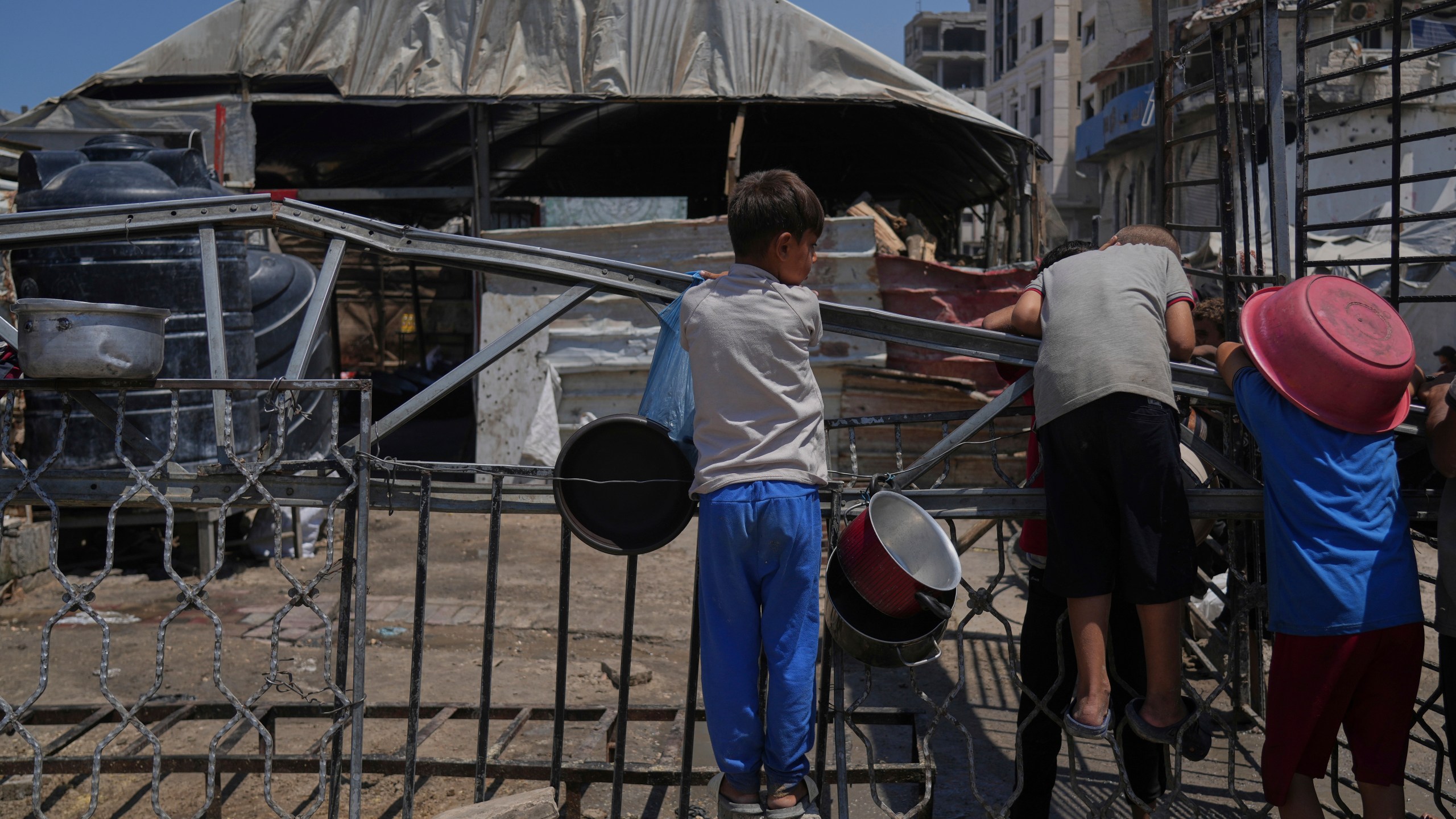 A Palestinian children wait at a community kitchen before donated food is prepared and distributed in Gaza City, Friday, Aug. 22, 2025. (AP Photo/Abdel Kareem Hana)