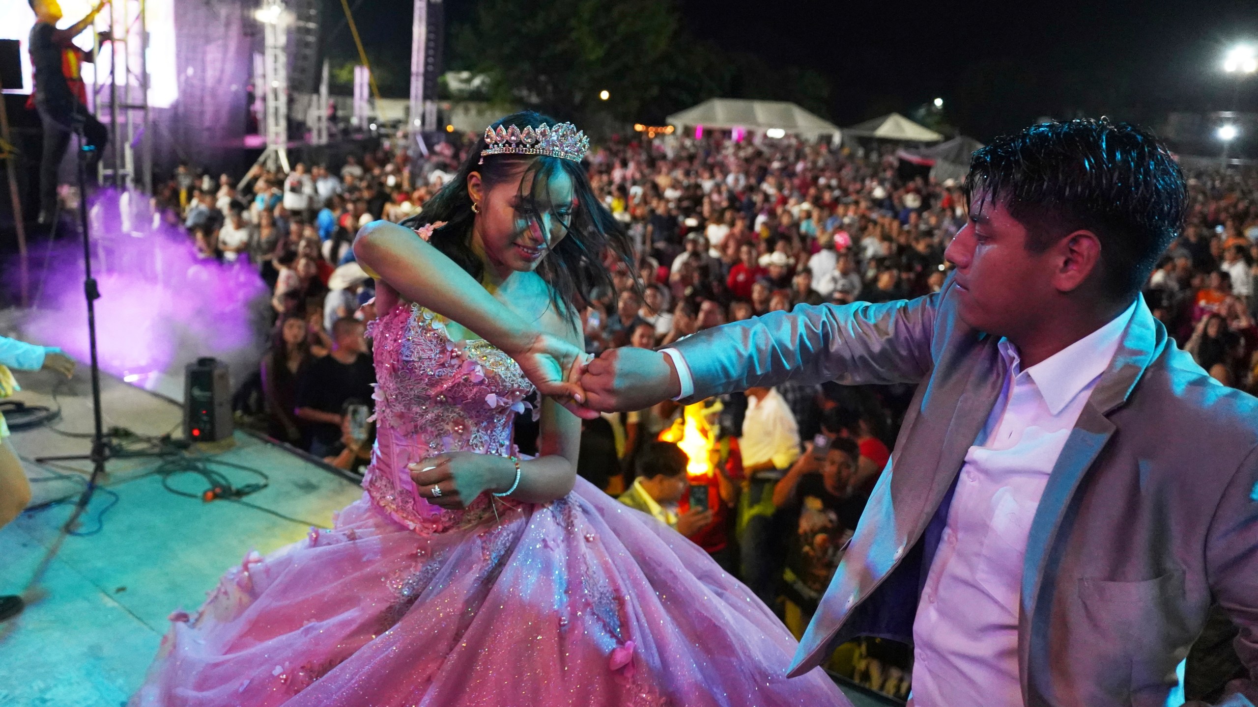 Isela Anali Santiago Morales dances during her 15th birthday party at a stadium in Axtla de Terrazas, Mexico, Saturday, Aug. 23, 2025, organized by the community after her father's social media appeal drew support following her first sparsely attended party. (AP Photo/Mauricio Palos)