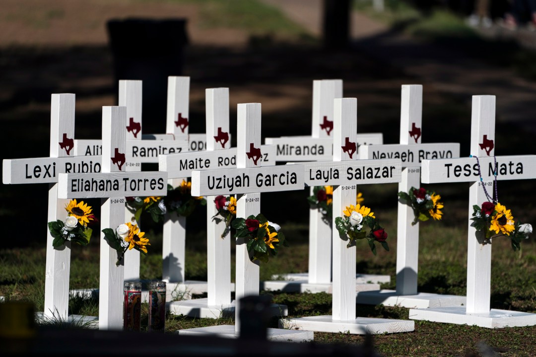 Crosses with the names of shooting victims in the lawn outside Robb Elementary School