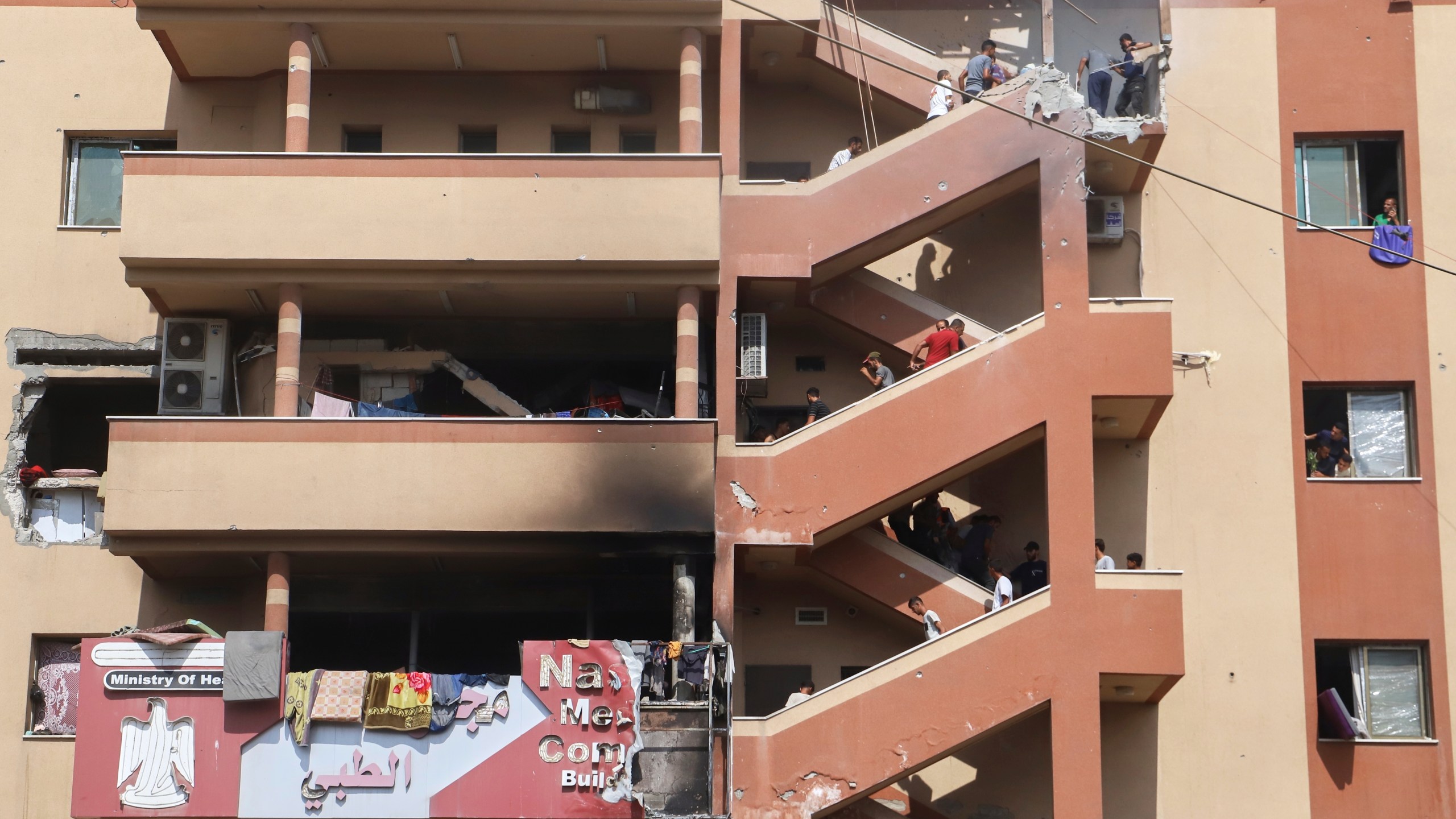 People walk up the stairs to the site of an Israeli strike, minutes before a second strike hit the same spot, killing at least 22 people in total, including five journalists, at Nasser Hospital in Khan Younis, southern Gaza Strip, Monday, Aug. 25, 2025. This was one of the last photos taken by journalist Mariam Dagga, who freelanced for The Associated Press and other outlets, before she walked to the site and was killed in the second strike. (AP Photo/Mariam Dagga)