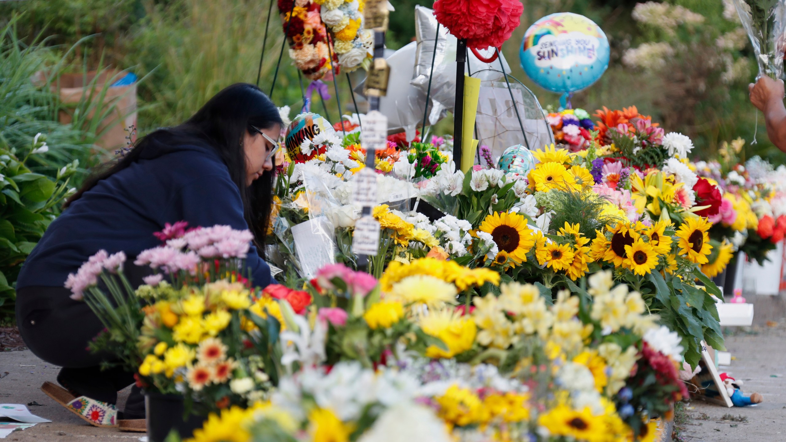 People visit a make-shift memorial at Annunciation Catholic Church after the Wednesday's shooting at the school, Friday, Aug. 29, 2025, in Minneapolis. (AP Photo/Bruce Kluckhohn)
