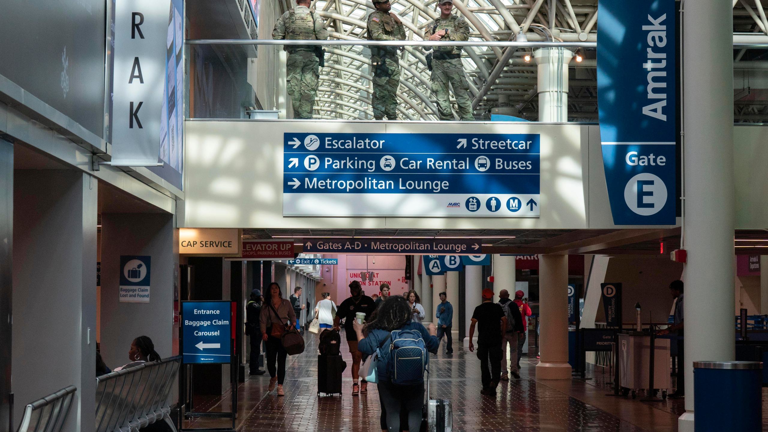 Members of the Louisiana National Guard, top, patrol the passengers area in Union Station, Saturday, Aug. 30, 2025, in Washington. (AP Photo/Jose Luis Magana)