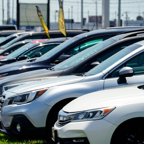 Used cars for sale are parked roadside at an auto lot