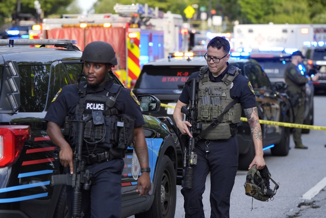 Armed police officers walk near the scene of shooting at the Emory University in Atlanta on Friday, Aug. 8, 2025