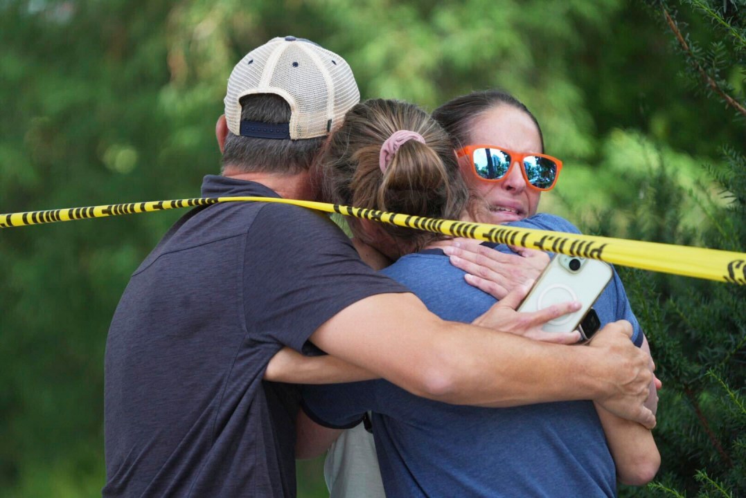 Community members hug after the shooting at Annunciation Catholic School in Minneapolis.