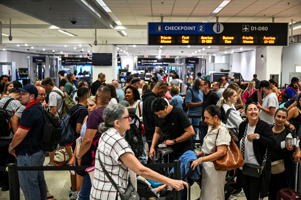 Passengers at Miami International Airport line up at at a security check-point