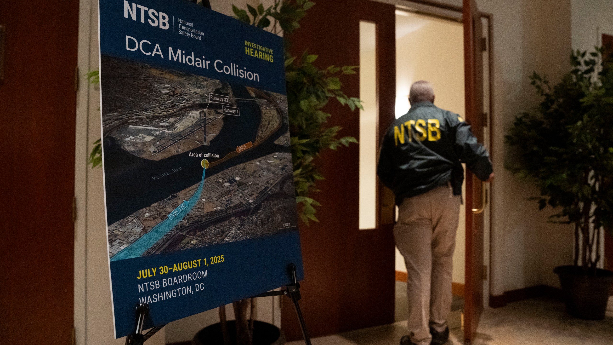 A National Transportation Safety Board worker enters the hearing room