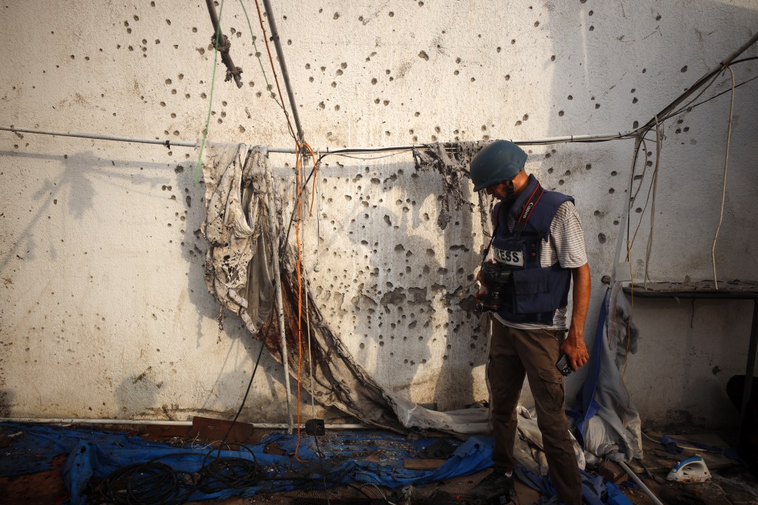 Journalist looks at destroyed tent in Gaza