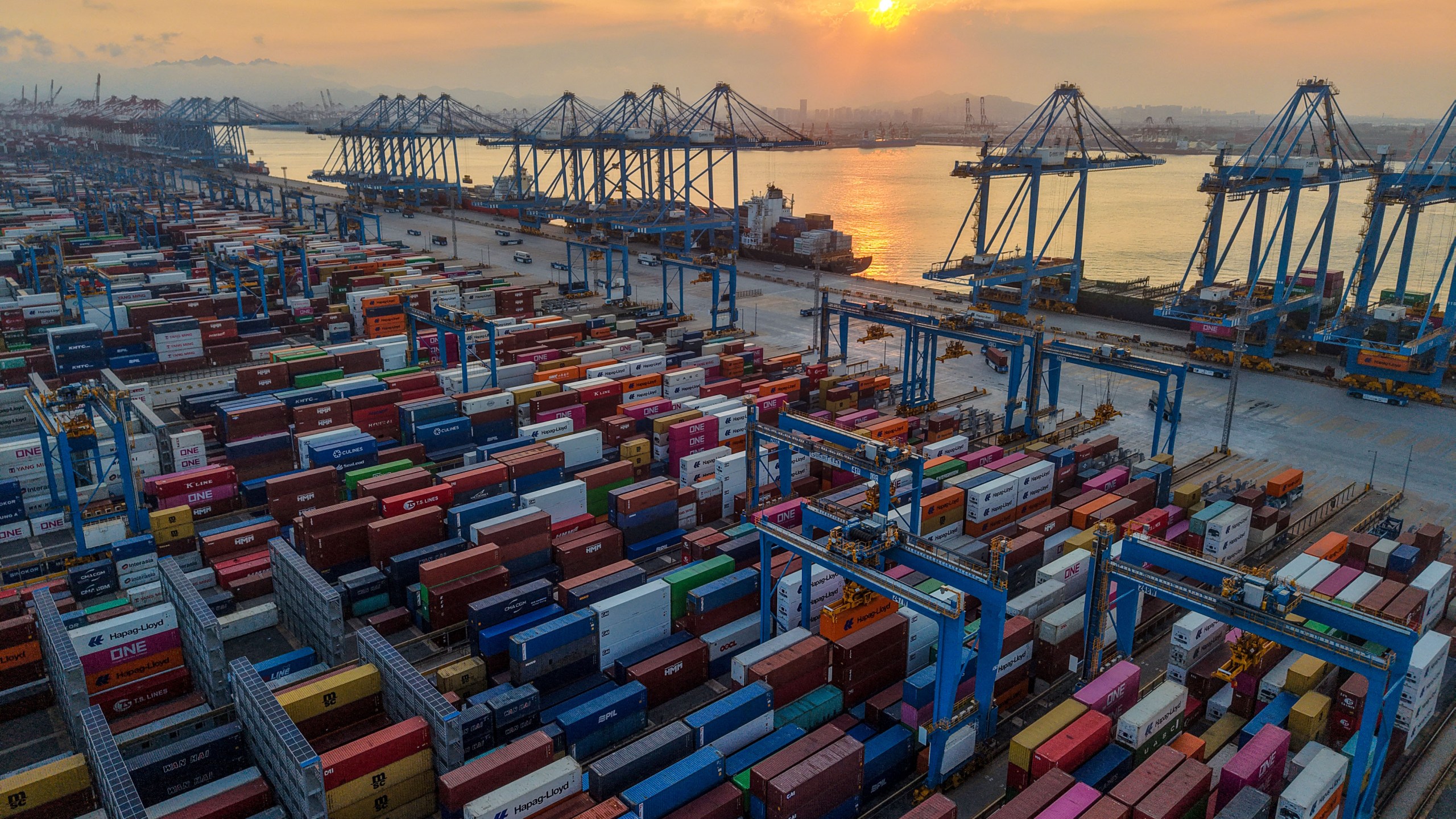 shipping containers at a port during sunset