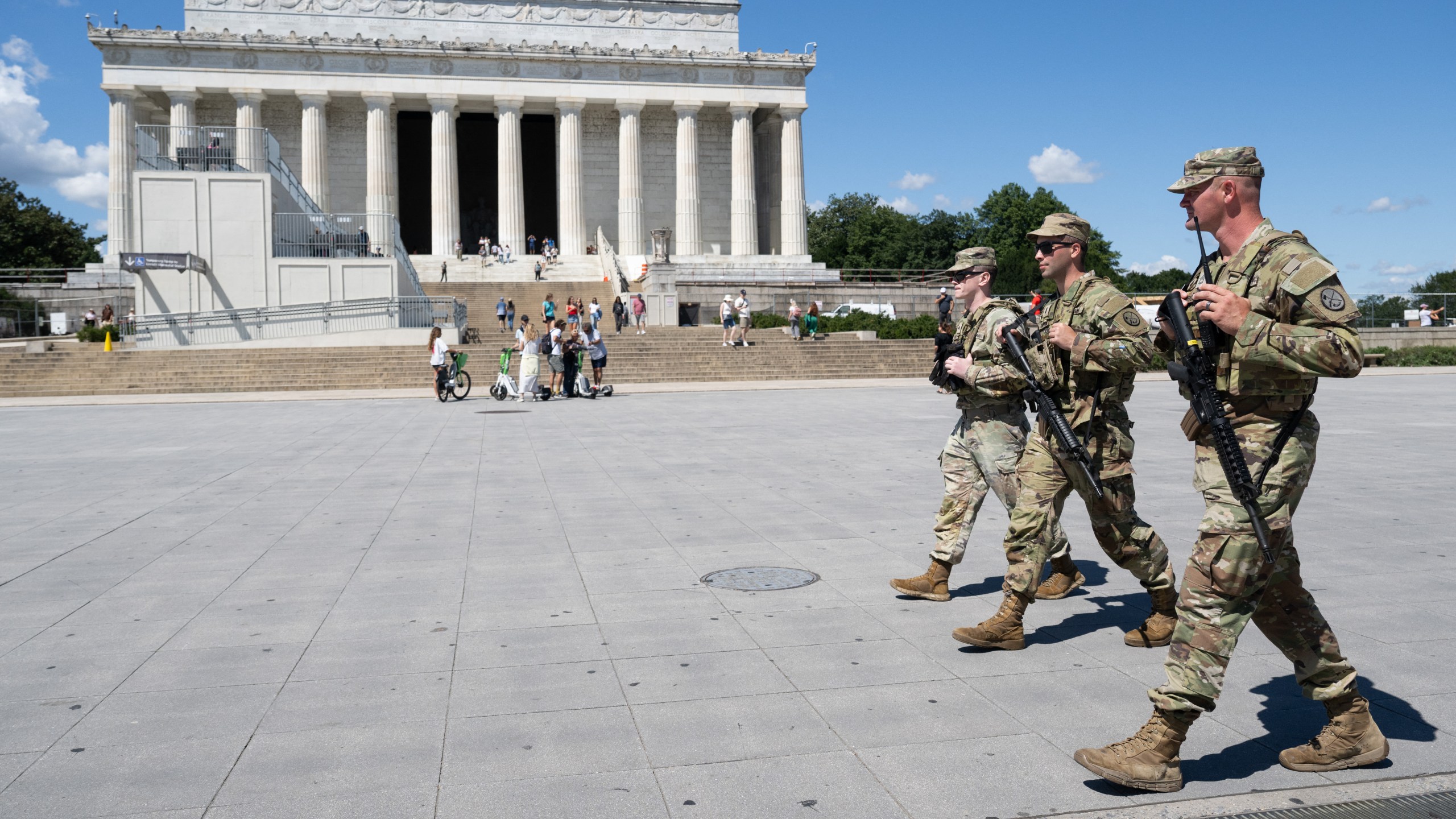 Armed members of the National Guard patrol on the National Mall