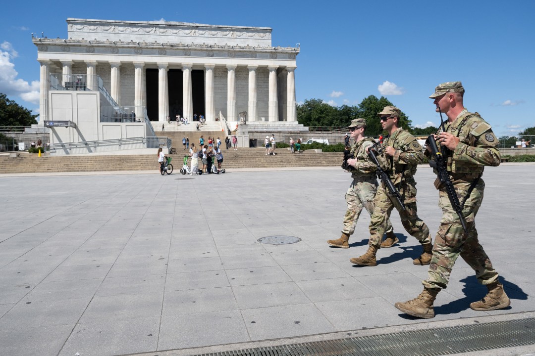 Armed members of the National Guard patrol on the National Mall