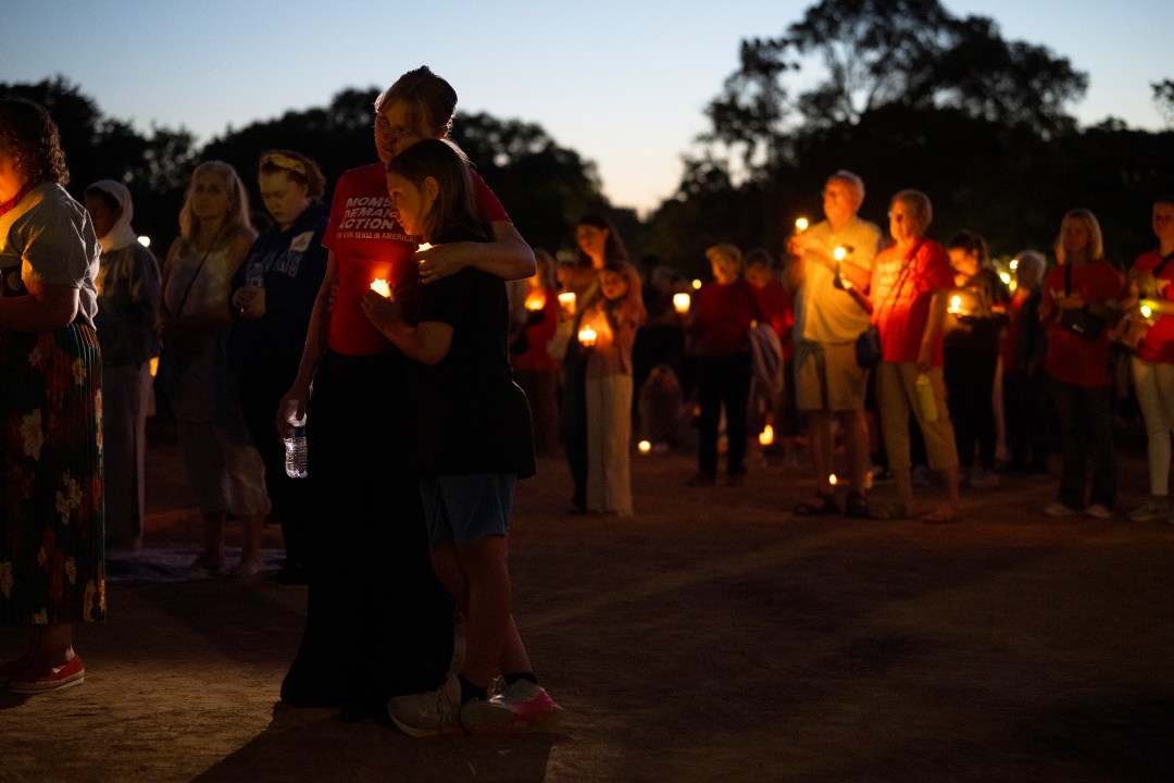 People holding candles attend a vigil at a church