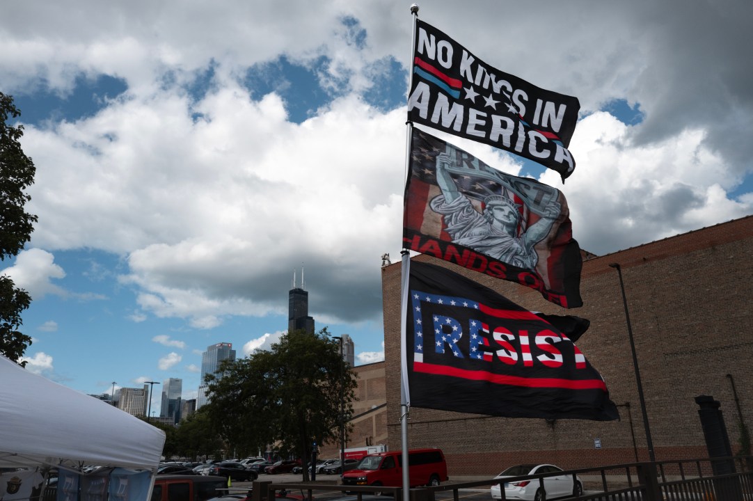 Bernie Sanders signs flying in foreground, Chicago skyscrapers in the background amid clouds