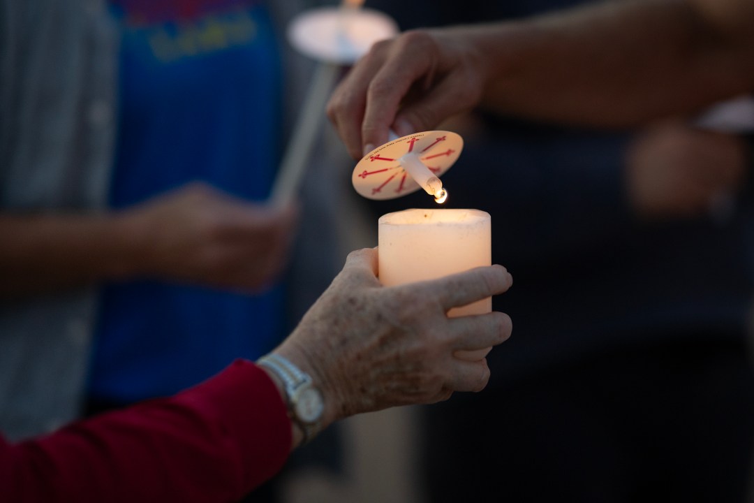 Vigil attendees light candles after Annunciation Catholic School shooting