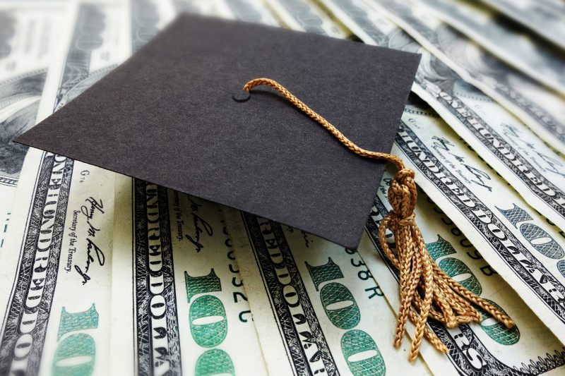 Graduation cap pictured on top of money