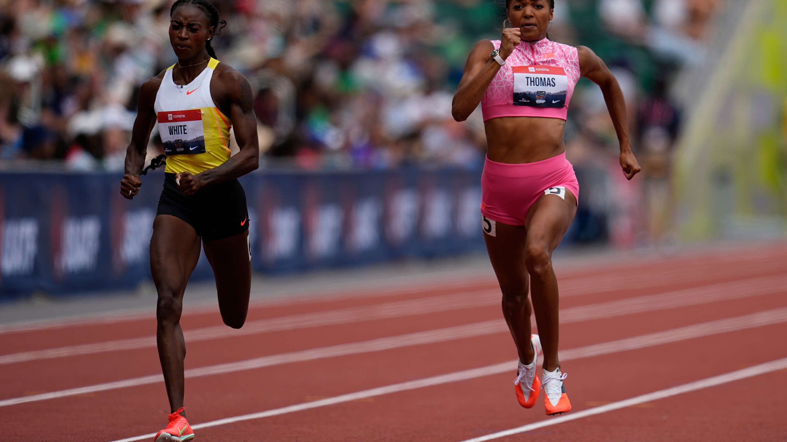 Kayla White, left, and Gabby Thomas compete in the third heat of the women's 200-meter semifinal at the U.S. Championships athletics meet in Eugene, Ore., Sunday, Aug. 3, 2025. (AP Photo/Abbie Parr)